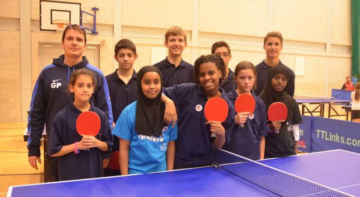 Gabor Papp, one of the owners of clueQuest with a team of students as a table tennis teacher